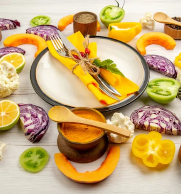 Table setting with plate, cutlery, and colorful vegetables and spices