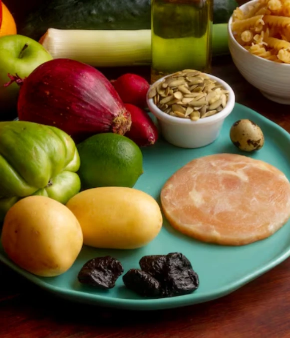 Plate with mixed foods and vegetables on table