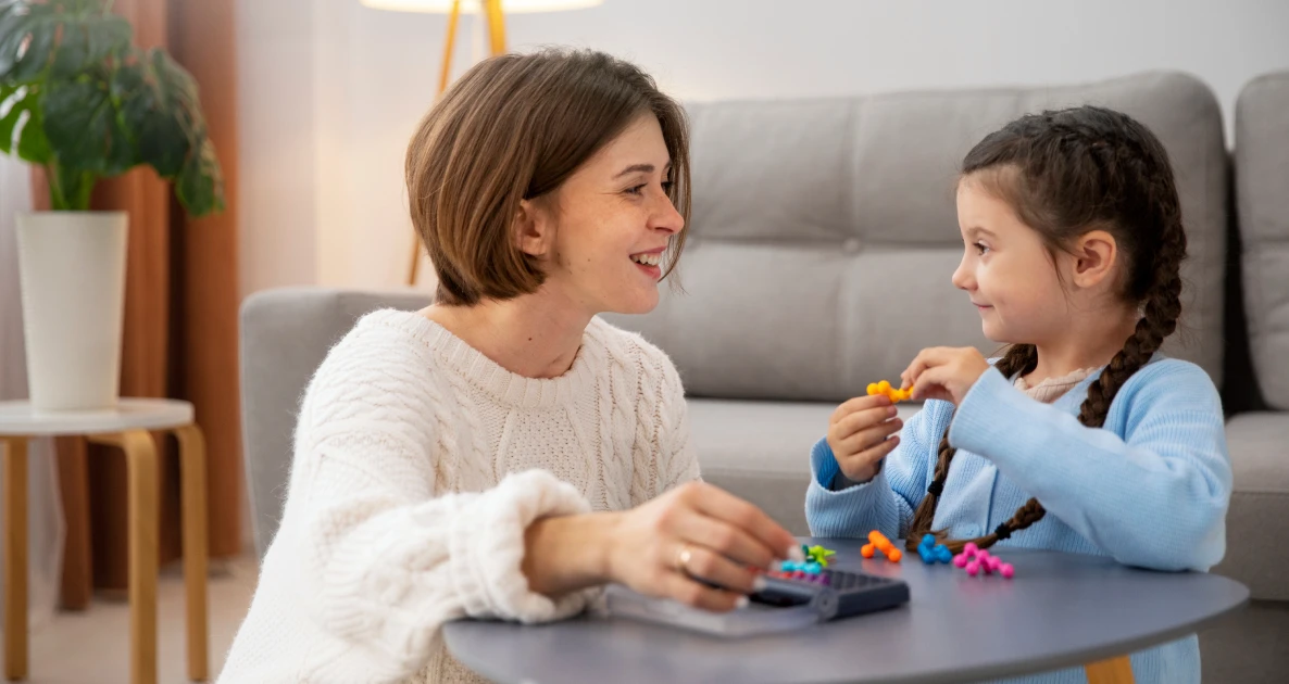 Woman and girl play board game in cozy room, smiling warmly.