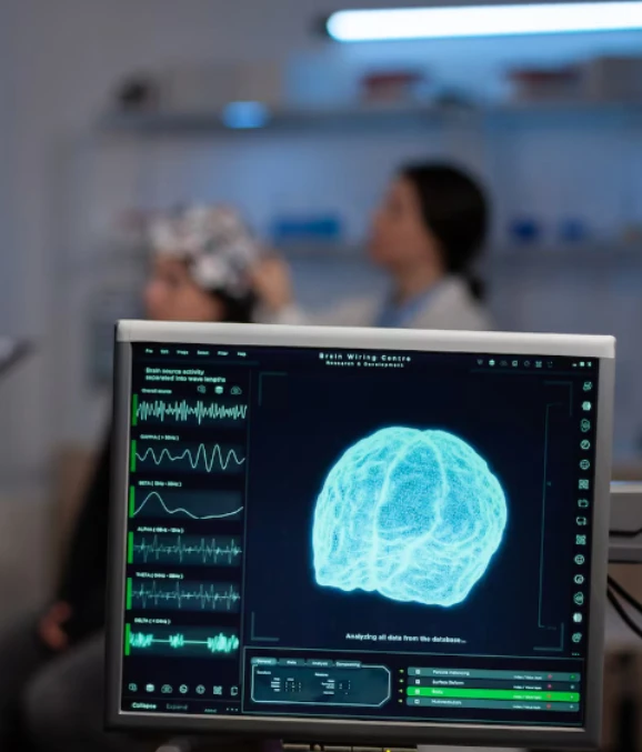 Monitor showing brain scan and neural graphs in lab, EEG in background.