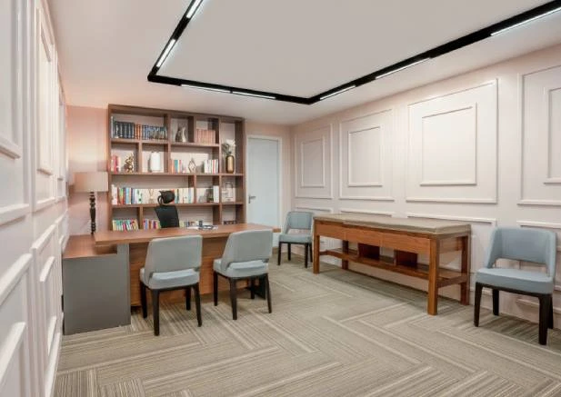 A modern office or consultation room with a wooden desk, a bookshelf, and light blue chairs.