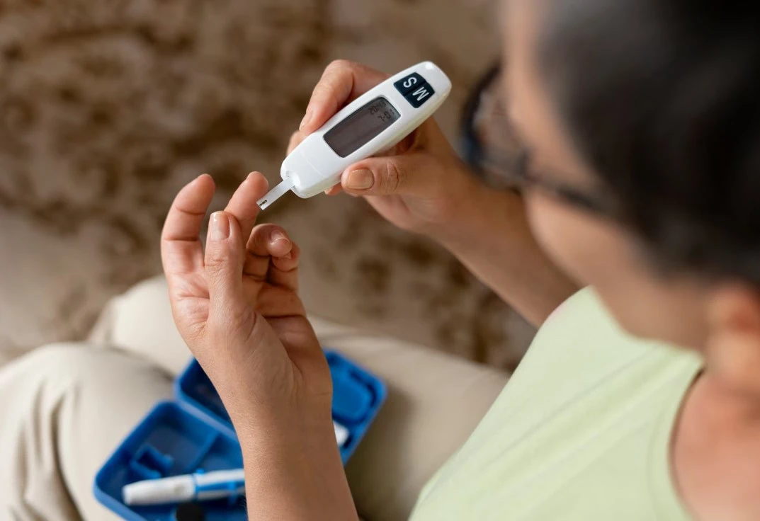 Person checking blood sugar with glucose meter.