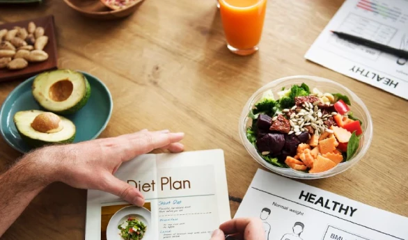 Person reviewing diet plan with healthy food on table