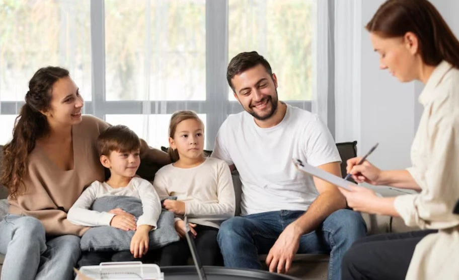 Family counseling session with therapist taking notes.