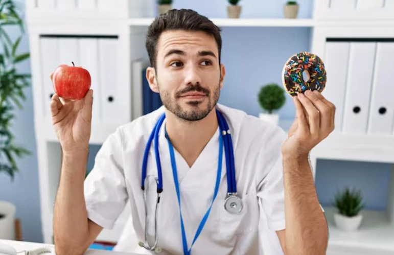 Doctor choosing between apple and donut in office