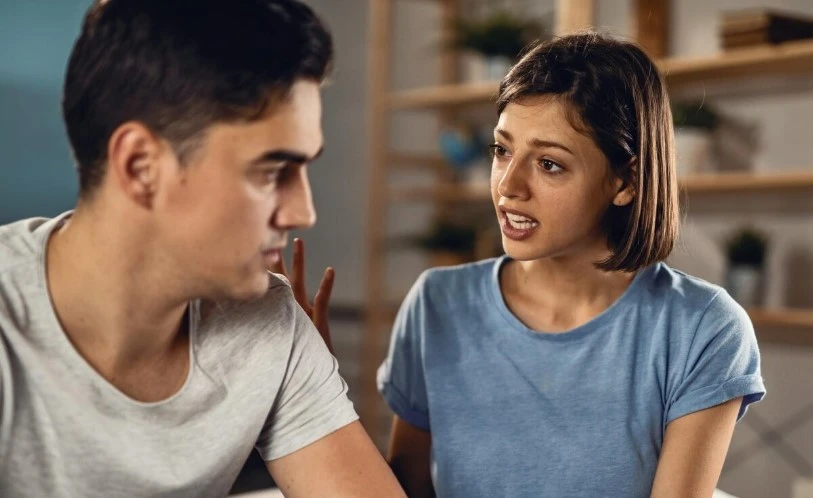 Woman speaking to man in tense conversation.