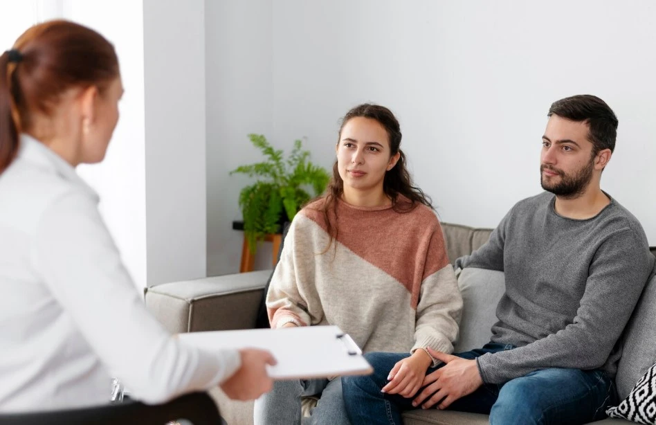 Couple listens to a therapist in a calm room.