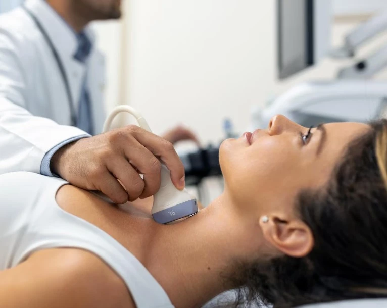 Doctor performing neck ultrasound on patient.